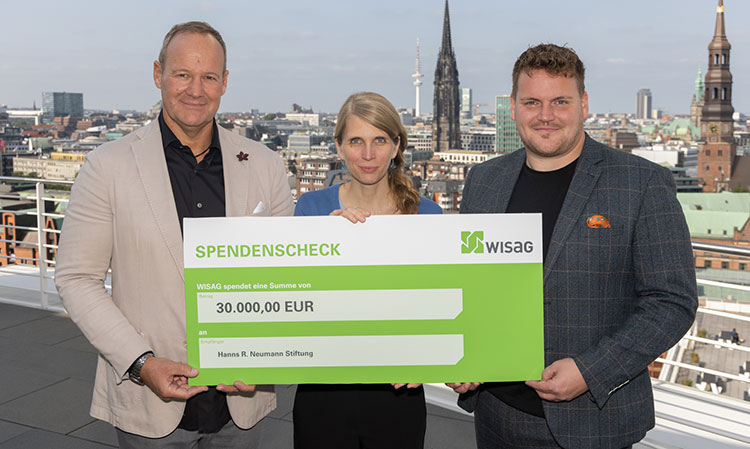 Um die Lebensbedingungen von Kaffeekleinbauern in Honduras zu verbessern, überreichten Ralf Meyer (l.), Geschäftsführer Chicco di Caffè, und Kai-Uwe Trempel, Geschäftsführer Wisag Business Catering Nord-West, einen Spendenscheck in Höhe von 30.000 Euro an Corinna Mertz, Program and Partnership Managerin bei der Hanns R. Neumann Stiftung. Foto: 2024 michaelbogumil.com